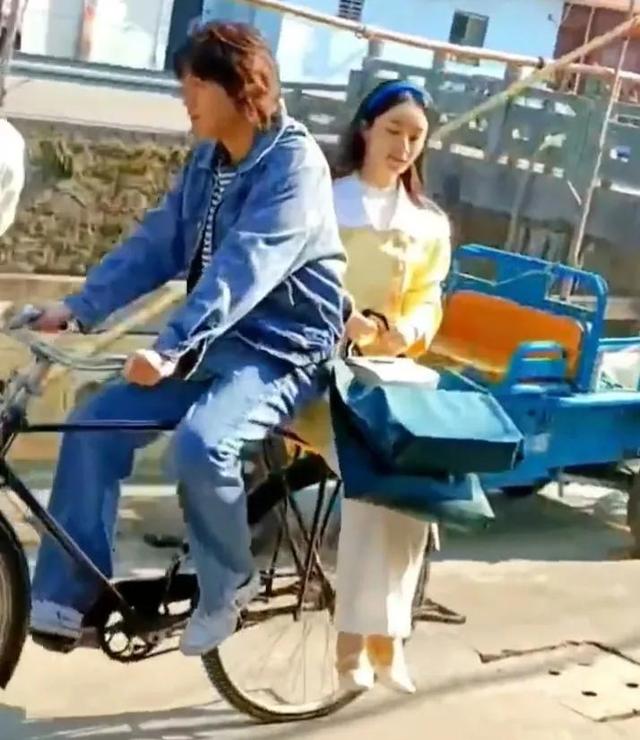 欧欧的《野蛮生长》中，赵坐在自行车后座上，像个乖巧的媳妇。
(图2)
