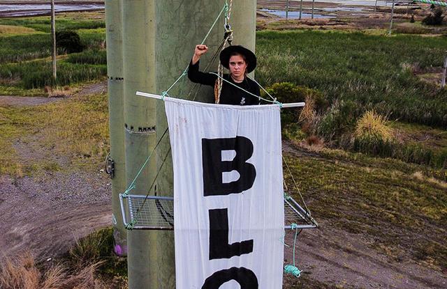 澳大利亚环保抗议者把自己绑在采煤机器上，逼停全球最大煤炭港口