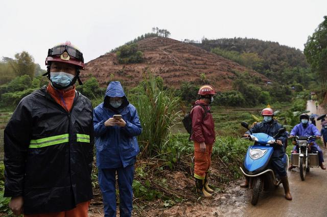 救援人员穿防护服泥泞中搜寻