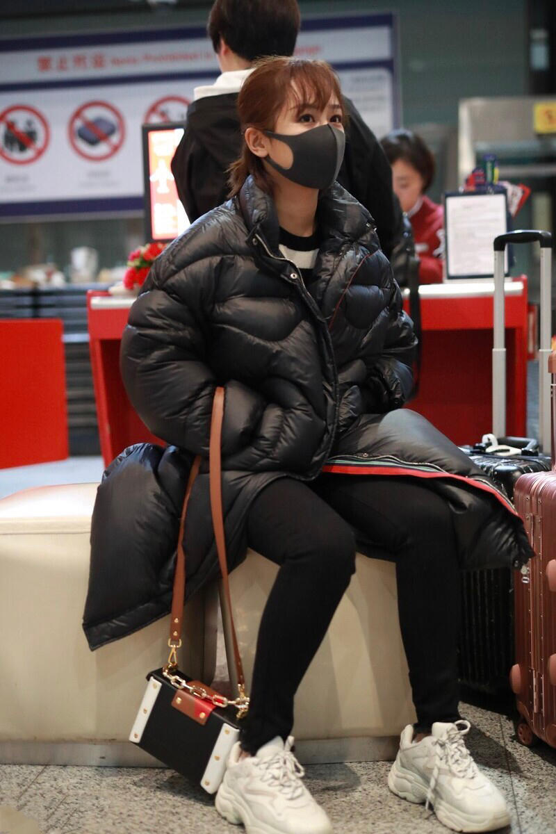 杨紫甜美走机场，一袭黑色长款羽绒服保暖又显瘦，风度温度一把抓