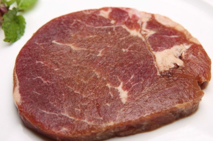 而合成牛排是把牛肉打碎,加入各种添加剂,然后用定量的模具压成的"