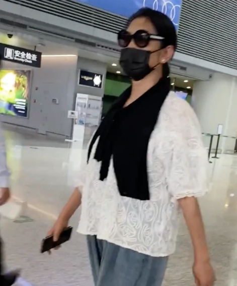 倪萍真是大妈们的时尚标杆，穿白上衣配黑围巾走机场，简约又减龄
