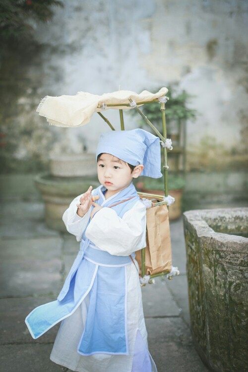 "小孩子只是嘿嘿地笑了几声,只顾着自己玩耍手中的布老虎.