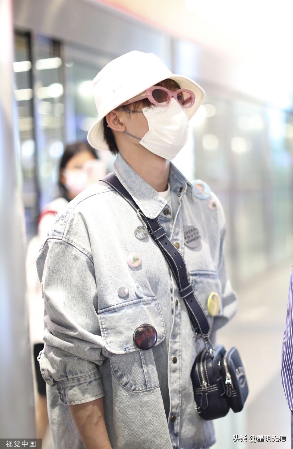 檀健次穿牛仔套装抵达机场 戴渔夫帽和粉框眼镜个性时尚