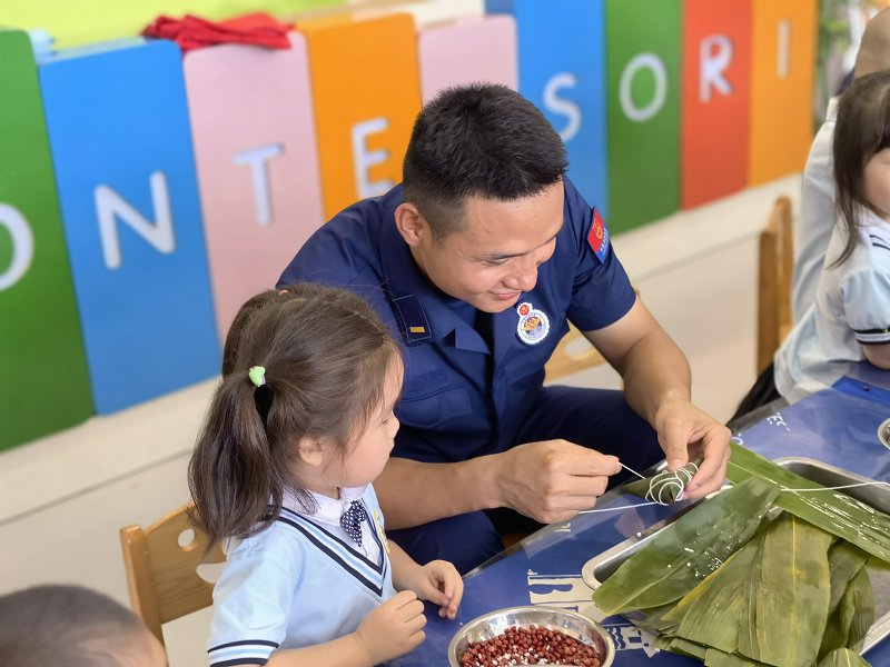 广西防城港：消防员与萌娃包粽子迎端午