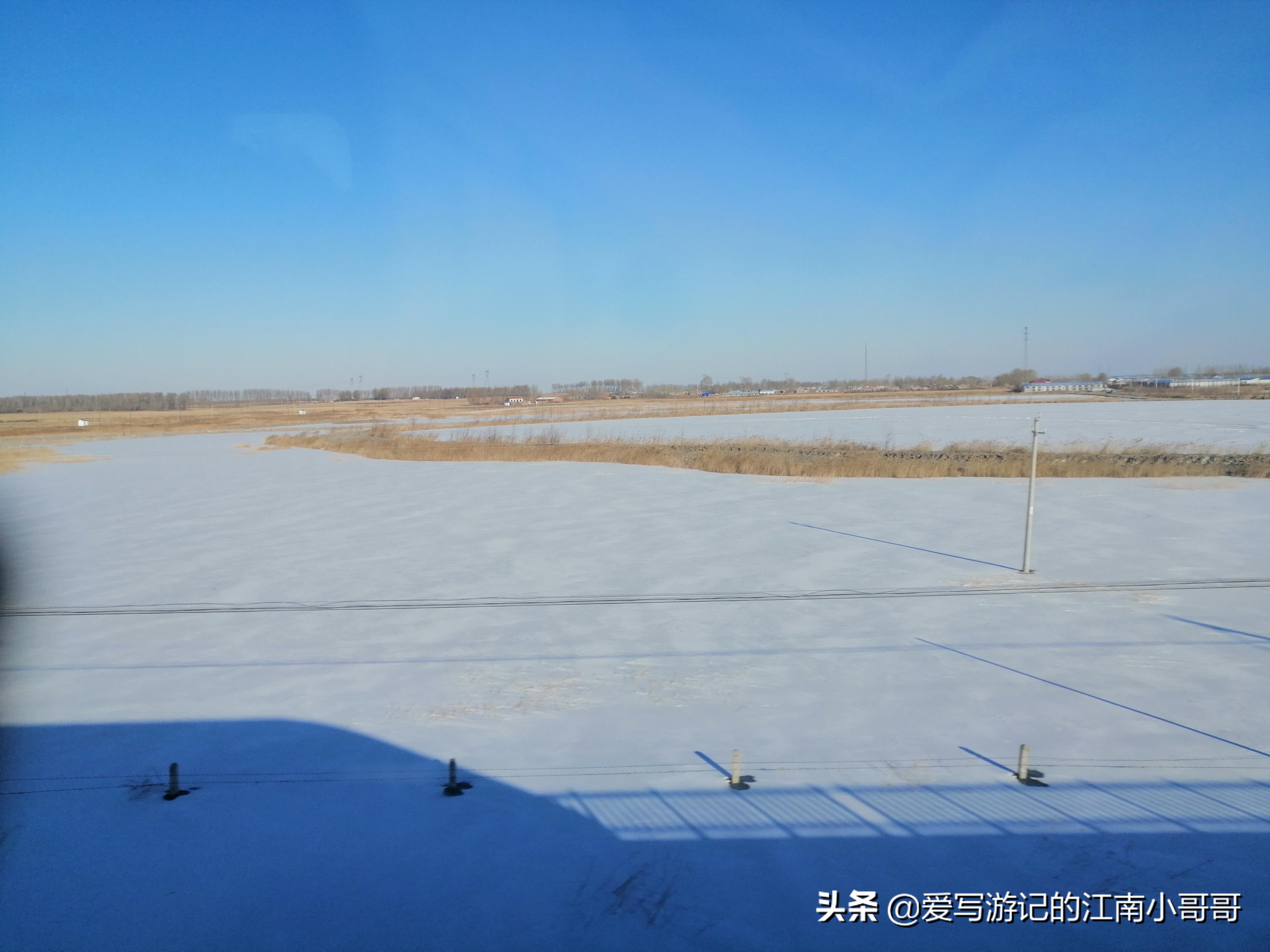 冬日白雪皑皑的田野里，巨大的白色烟柱在蓝天的映衬下扶摇直上