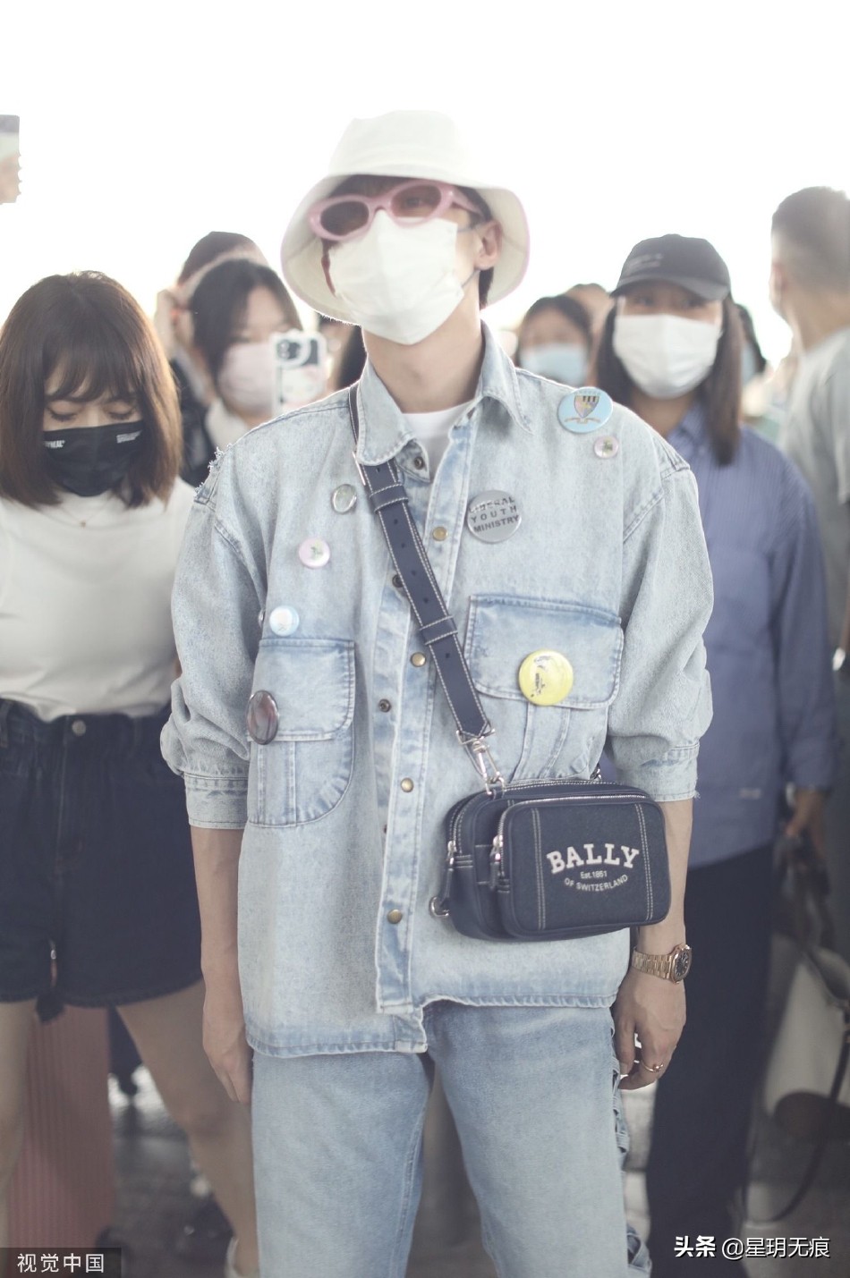 檀健次穿牛仔套装抵达机场 戴渔夫帽和粉框眼镜个性时尚