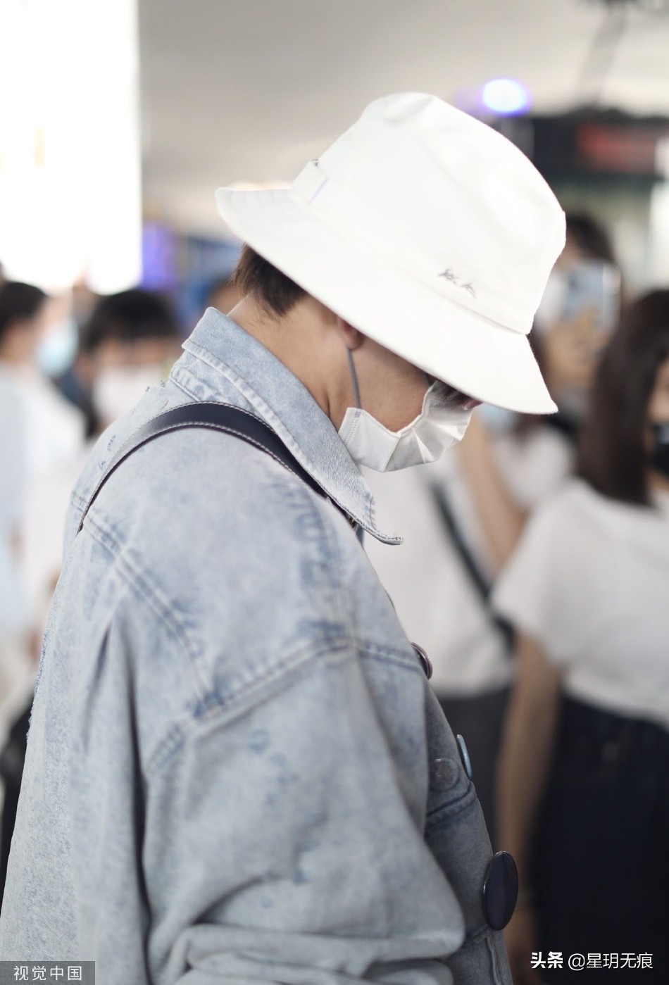 檀健次穿牛仔套装抵达机场 戴渔夫帽和粉框眼镜个性时尚