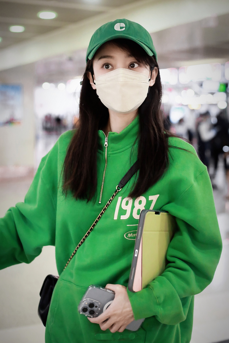 张小斐化身行走的种草机,休闲风卫衣走机场,戴绿色帽子格外抢眼