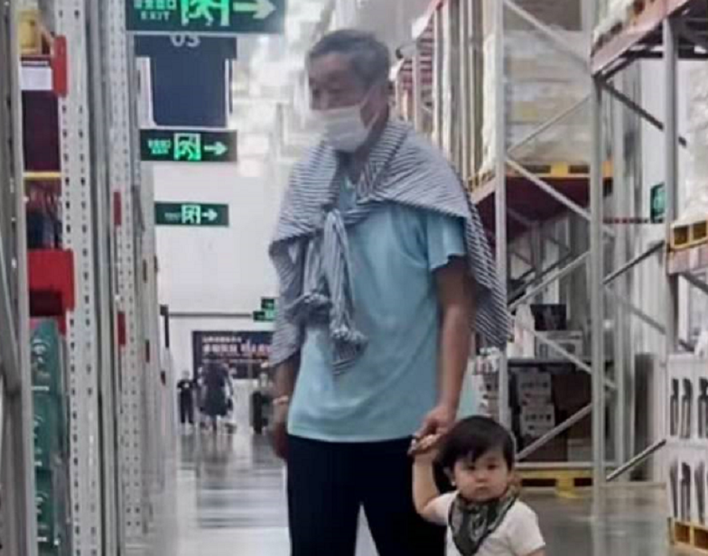 64岁杜源近况罕曝光，戴大金镯子与孙子现身商场，四处闲逛无人识