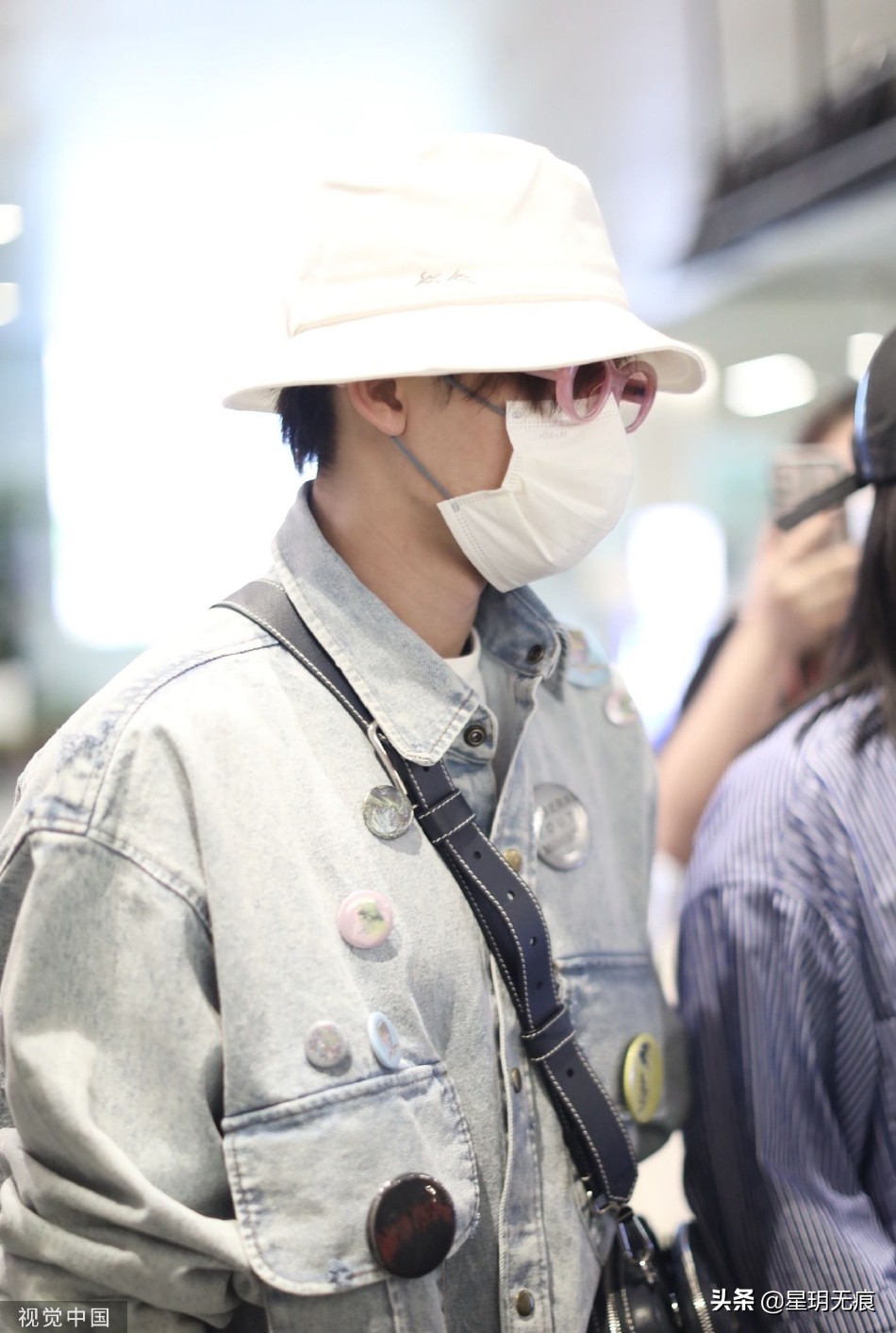 檀健次穿牛仔套装抵达机场 戴渔夫帽和粉框眼镜个性时尚