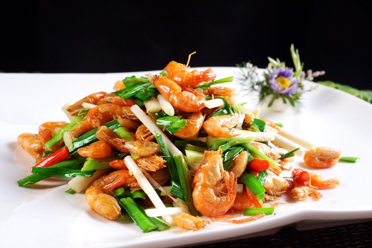 放入姜丝,蒜片炸出香味,然后捞出来,倒入河虾翻炒,变色后放入韭菜