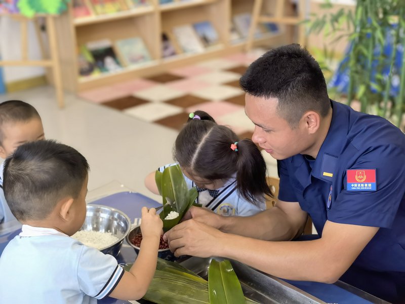 广西防城港：消防员与萌娃包粽子迎端午